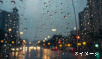 水滴のついたガラス越しの風景のイメージ画像