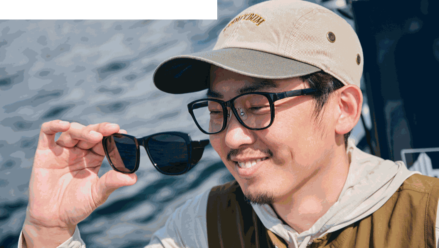 海辺でサングラスを手に持つ男性